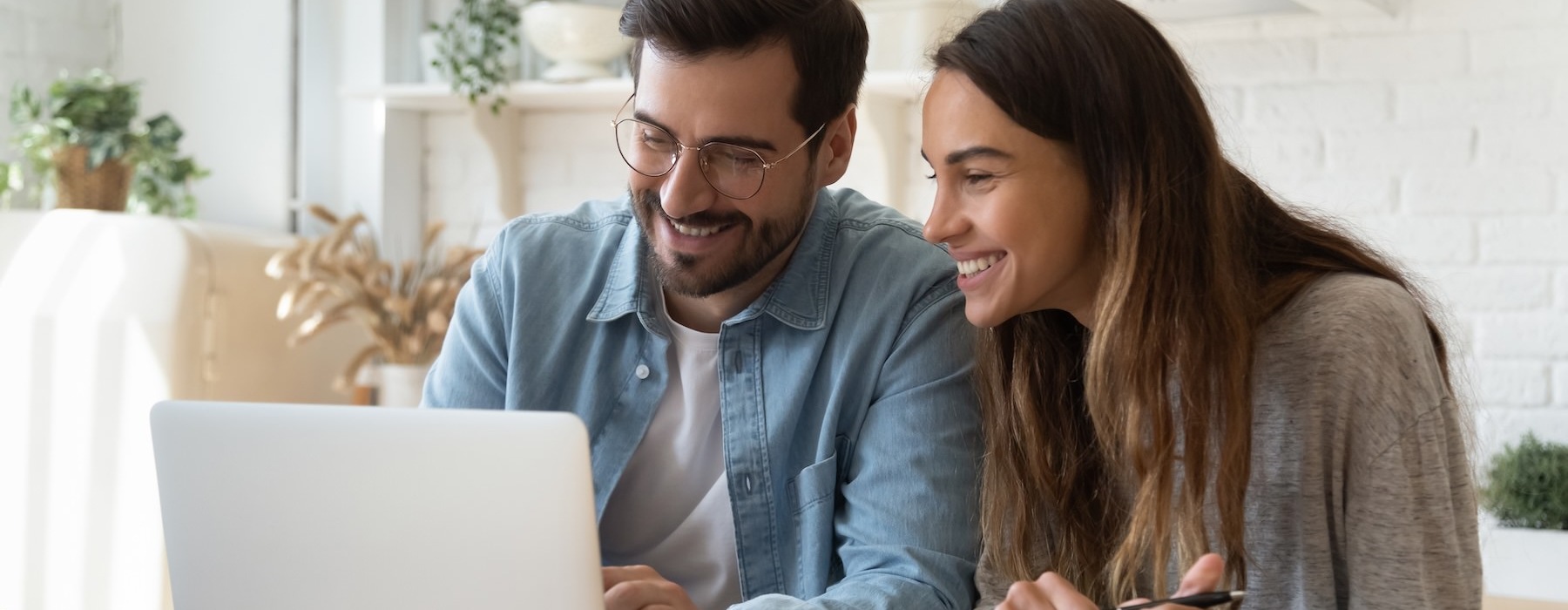 a man and a woman looking at a laptop